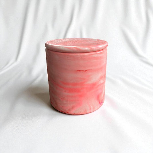 Pink ceramic jar with a lid on a white background