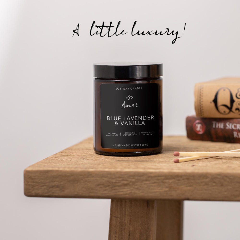 Soy wax candle labeled 'Amor' with blueberries and vanilla beans on a wooden surface.